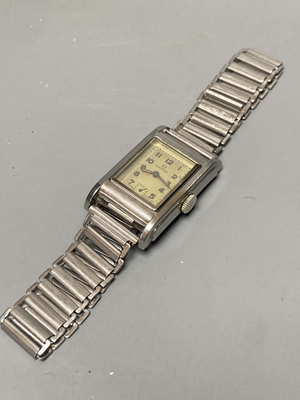 A gentlemans 1940s? stainless steel Omega manual wind wrist watch, with rectangular Arabic dial and subsidiary seconds,